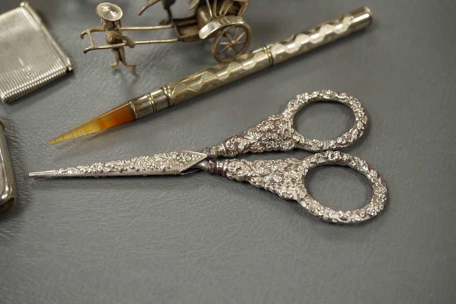 Sundry small silver and other items including a pig pin cushion, Adie & Lovekin, Birmingham, 1906, 45mm, a silver circular stamp case, a silver vesta case, a small sterling mounted notecase, three small metal rickshaws,